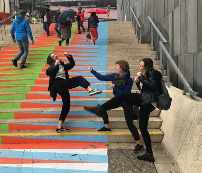 Three people on colourful stairs
